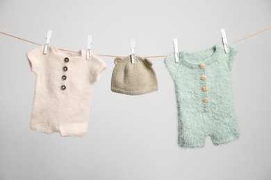 Photo of Baby clothes drying on washing line against white background