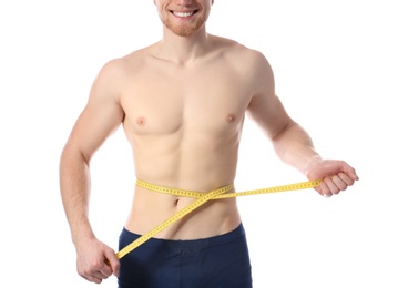 Young man with measuring tape showing his slim body on white background, closeup