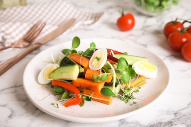 Photo of Salad with fresh organic microgreen in plate on white marble table, closeup