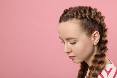 Photo of Woman with braided hair on pink background, space for text