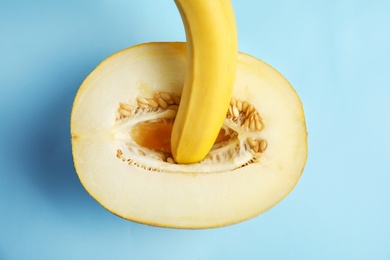 Photo of Flat lay composition with fresh banana and melon on blue background. Sex concept