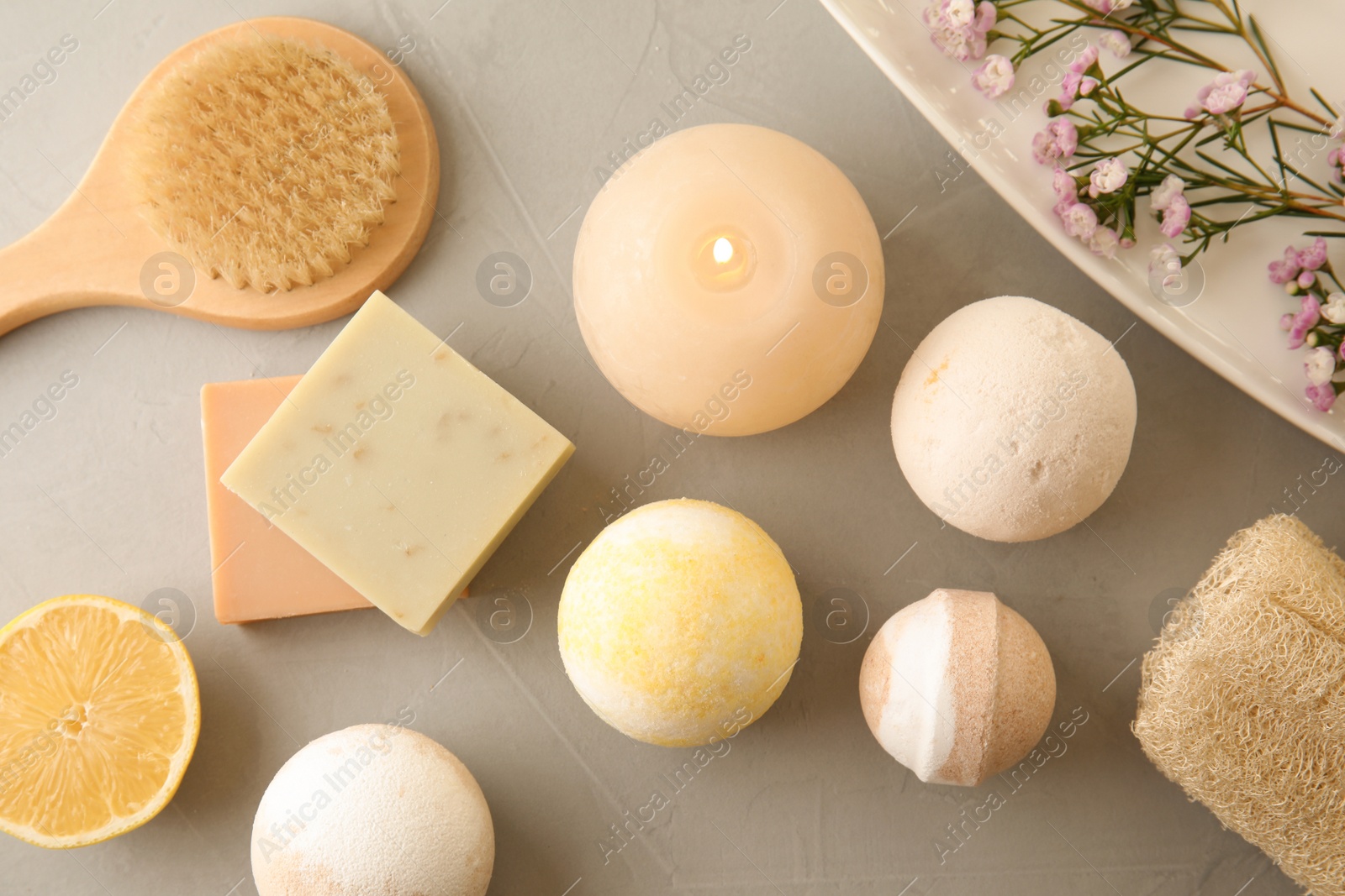 Photo of Flat lay composition with bath bombs and toiletries on grey background