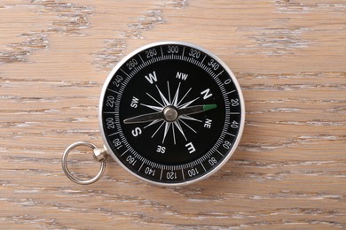 One compass on wooden table, top view. Tourist equipment