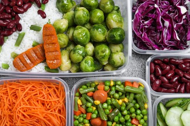 Photo of Set of plastic containers with fresh food on grey   table, flat lay