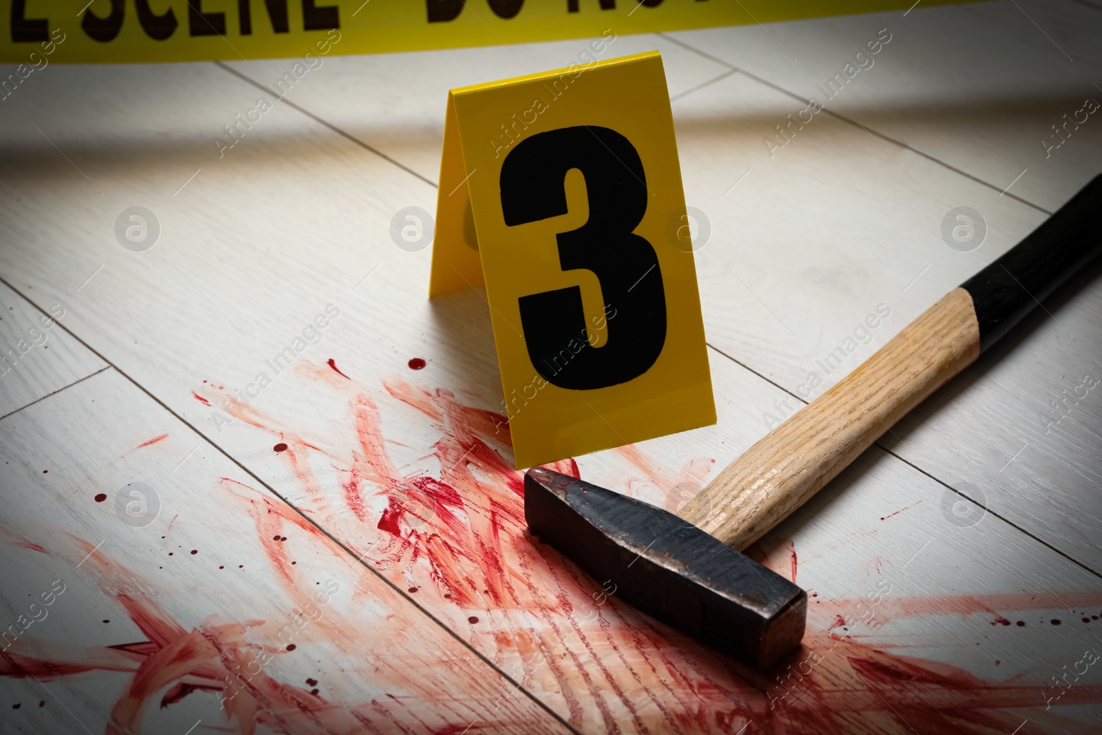Photo of Hammer with blood and crime scene marker on white wooden background, closeup
