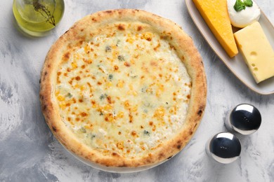 Delicious cheese pizza, oil and different kinds of cheese on light grey textured table, flat lay