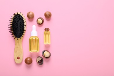 Delicious organic Macadamia nuts, natural oil and brush on pink background, flat lay. Space for text