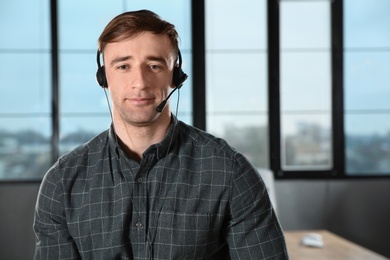 Male technical support operator with headset in office. Space for text
