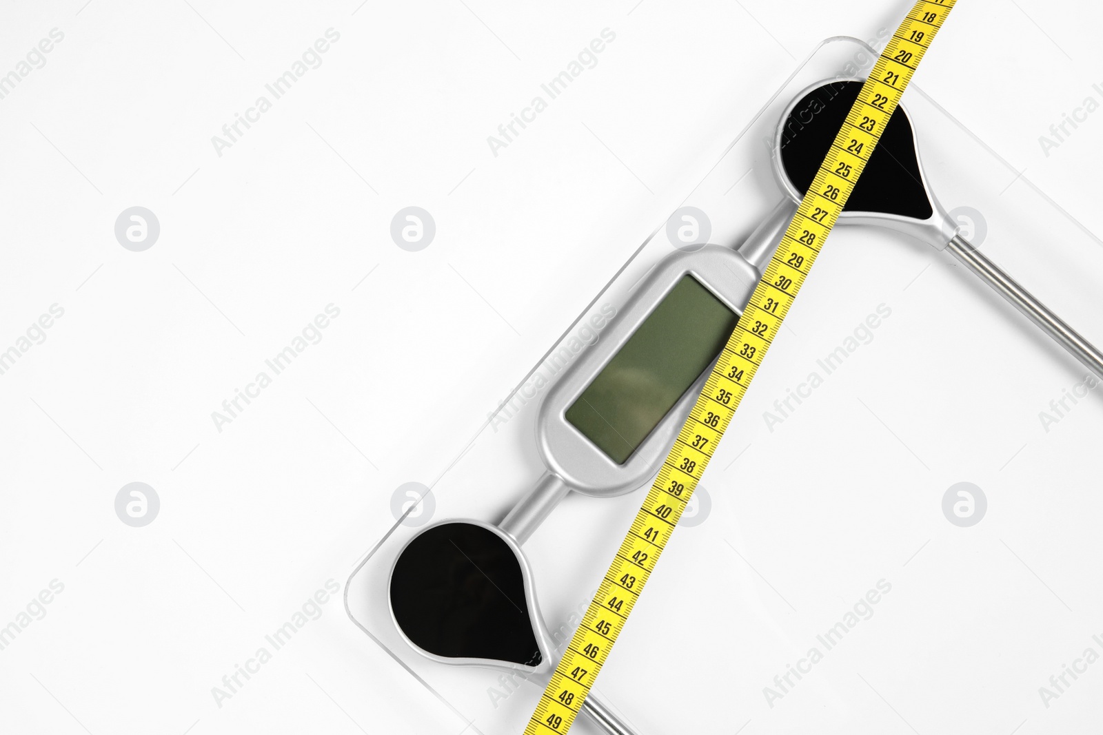 Photo of Modern scales and tape measure isolated on white, top view