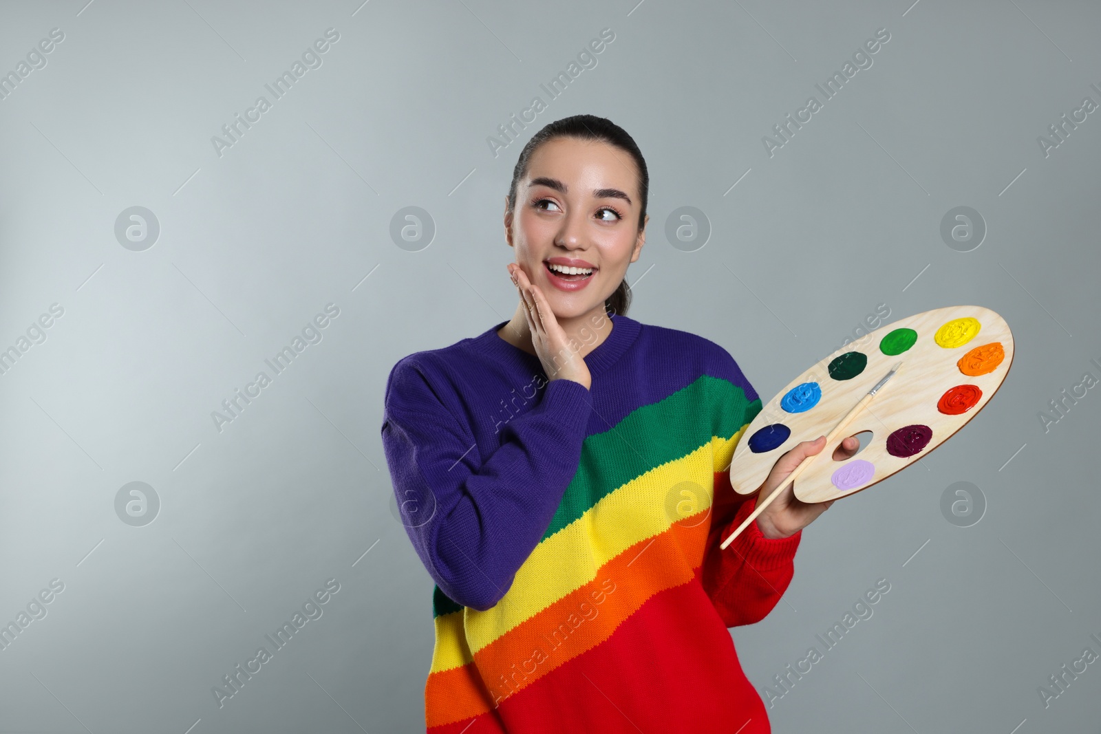 Photo of Woman with painting tools on grey background, space for text. Young artist