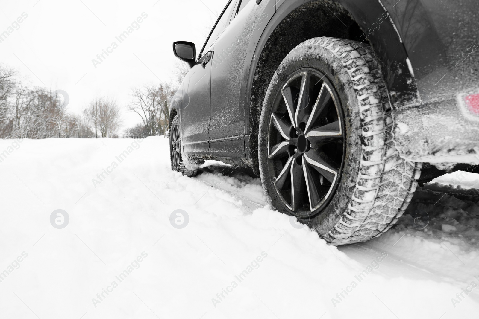 Photo of Snowy country road with car on winter day, closeup. Space for text