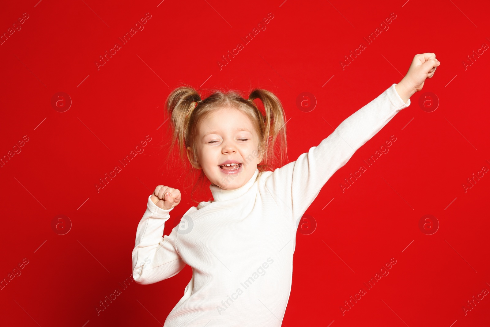 Photo of Portrait of cute little girl on red background