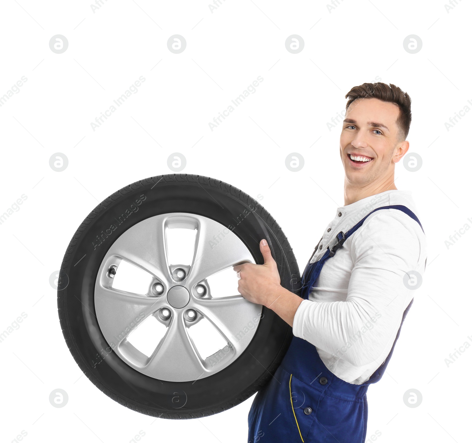 Photo of Male mechanic with car tire on white background