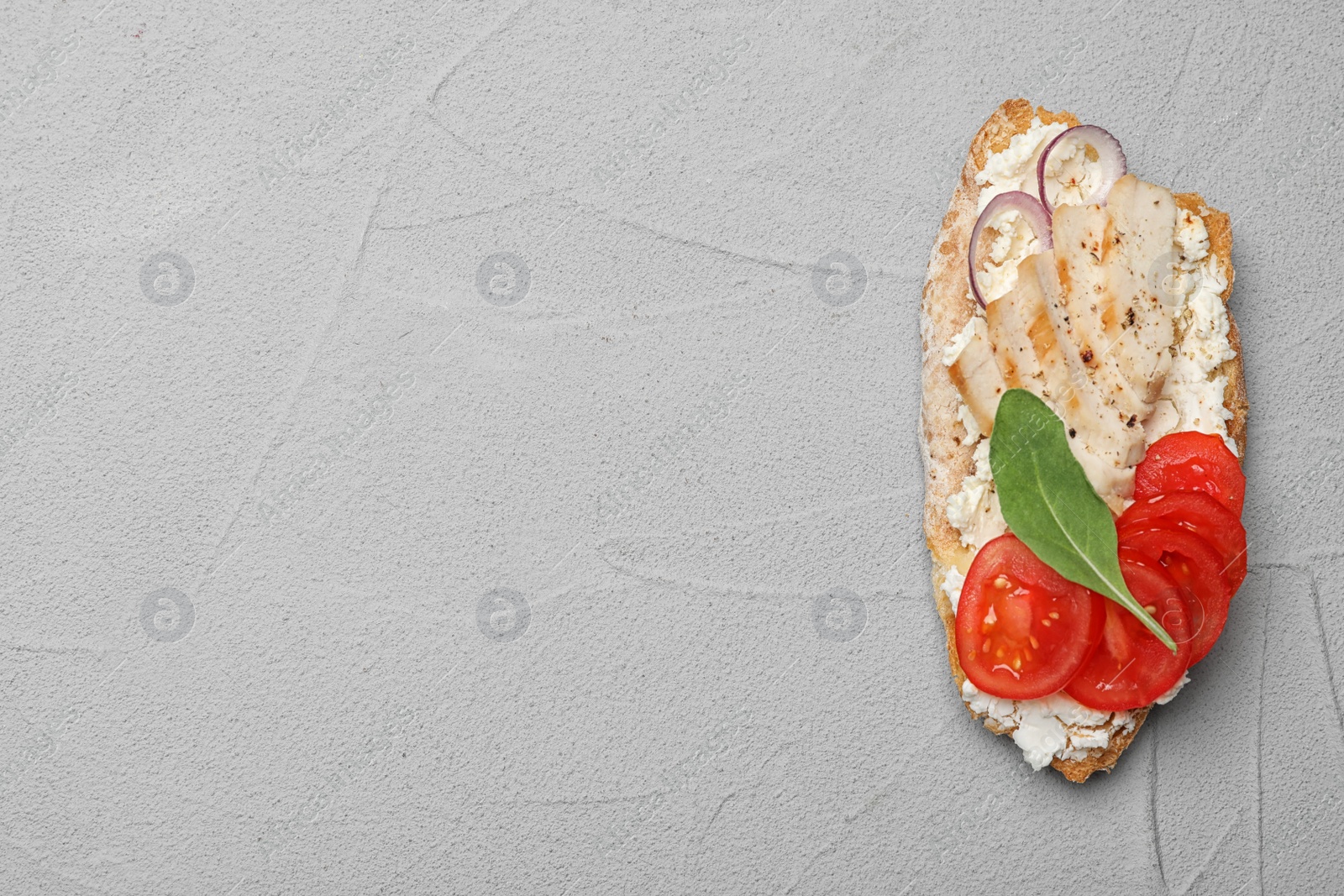 Photo of Delicious chicken bruschetta on light grey table, top view. Space for text