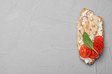 Photo of Delicious chicken bruschetta on light grey table, top view. Space for text
