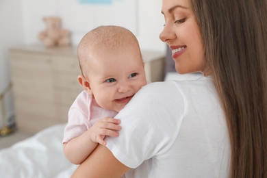 Mother holding her adorable baby at home