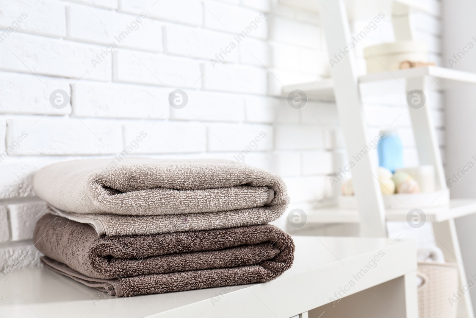 Photo of Stack of fresh towels on table in bathroom. Space for text