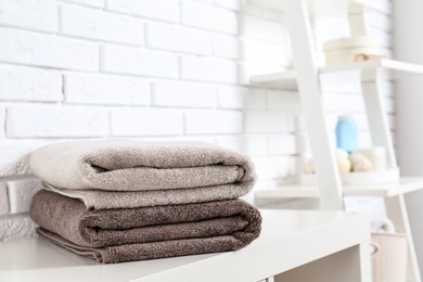 Stack of fresh towels on table in bathroom. Space for text