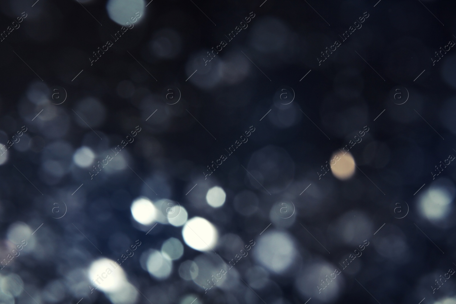 Photo of Silver glitter on dark background. Bokeh effect