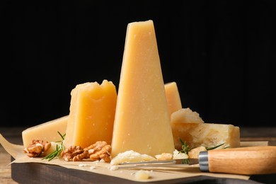 Delicious parmesan cheese with walnuts and rosemary on wooden board, closeup