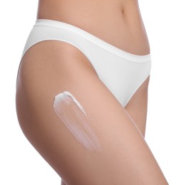Photo of Woman with body cream smear on hip against white background, closeup