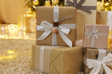 Photo of Many gift boxes near decorated Christmas tree at home