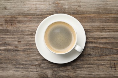 Photo of Aromatic coffee in cup on wooden table, top view