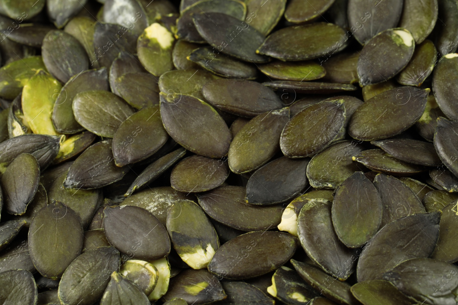 Photo of Many peeled pumpkin seeds as background, closeup