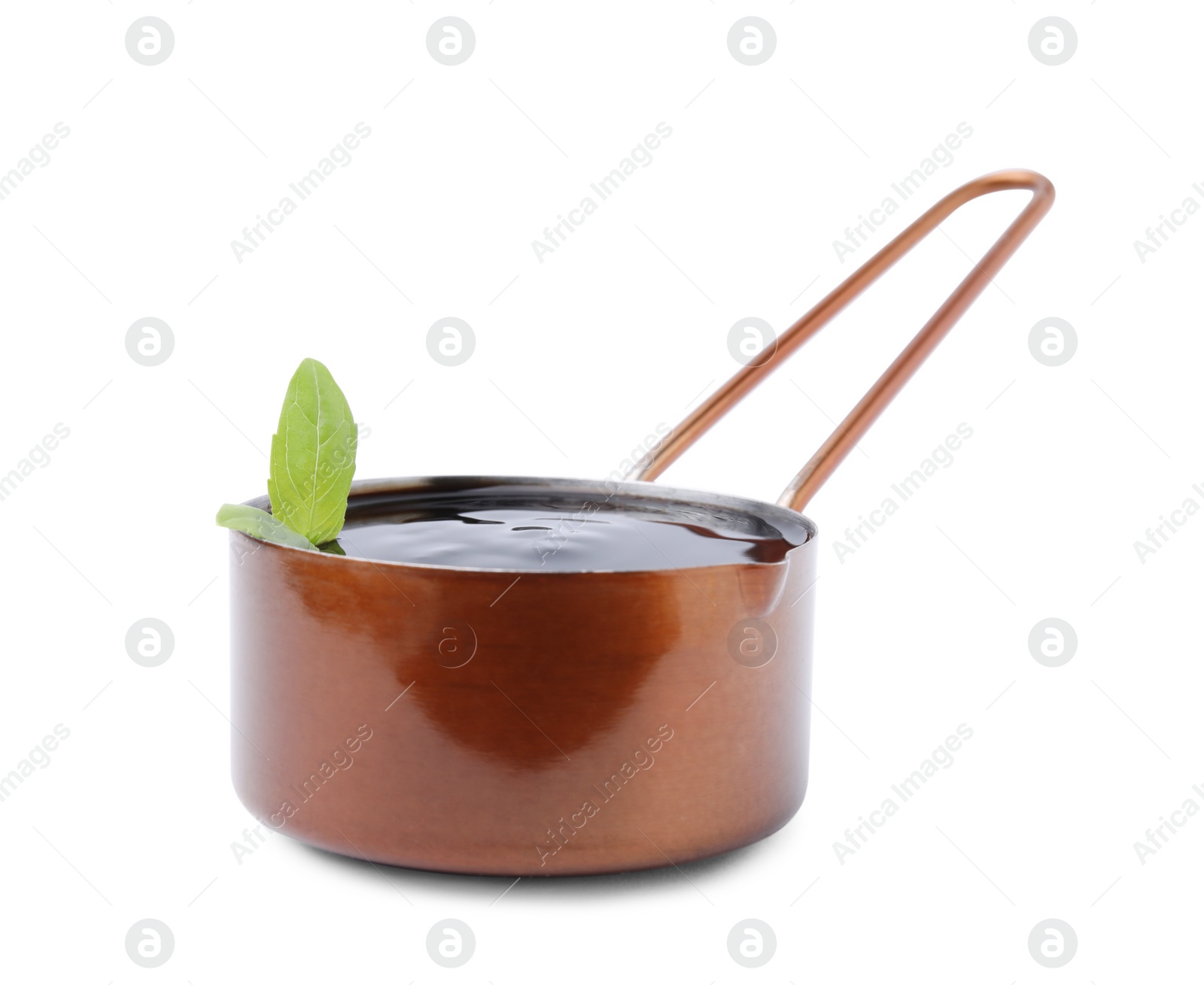 Photo of Balsamic glaze with basil leaves in metal small saucepan on white background