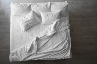 Comfortable bed with soft pillows indoors, top view