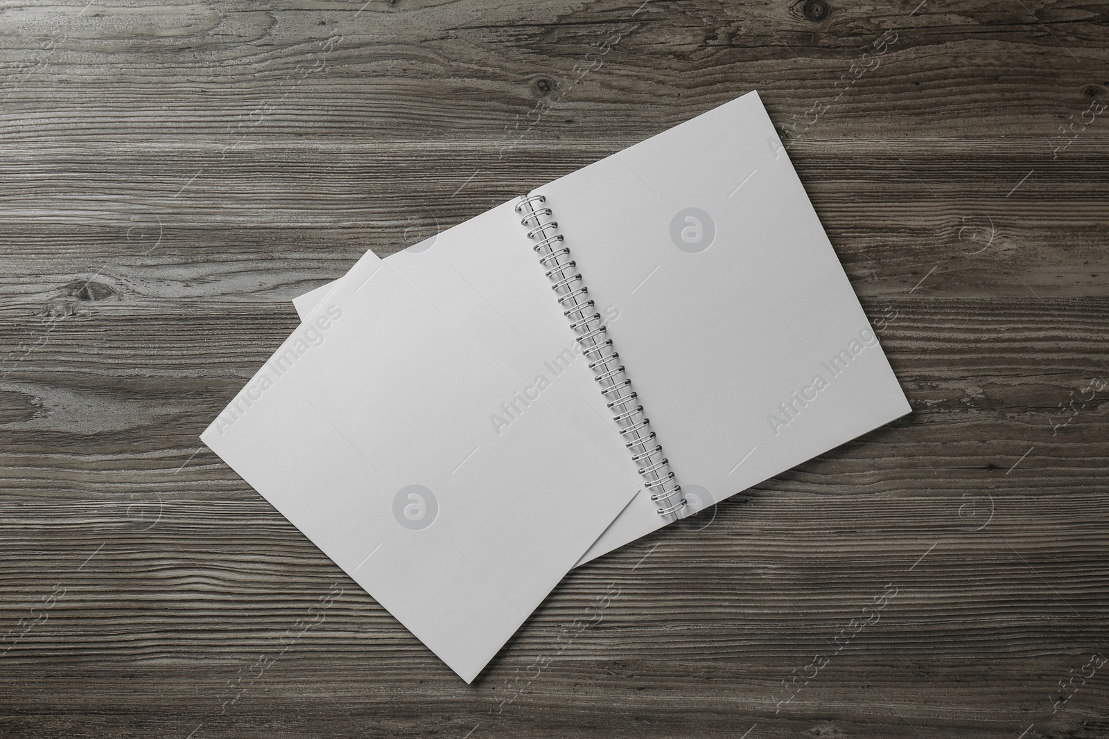 Photo of Sheet of paper and blank brochure on wooden table, flat lay. Mockup for design