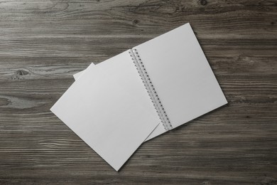 Sheet of paper and blank brochure on wooden table, flat lay. Mockup for design