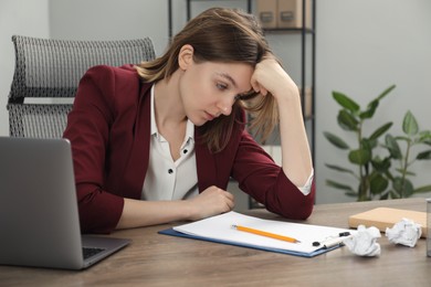Photo of Sad businesswoman working at wooden table in office