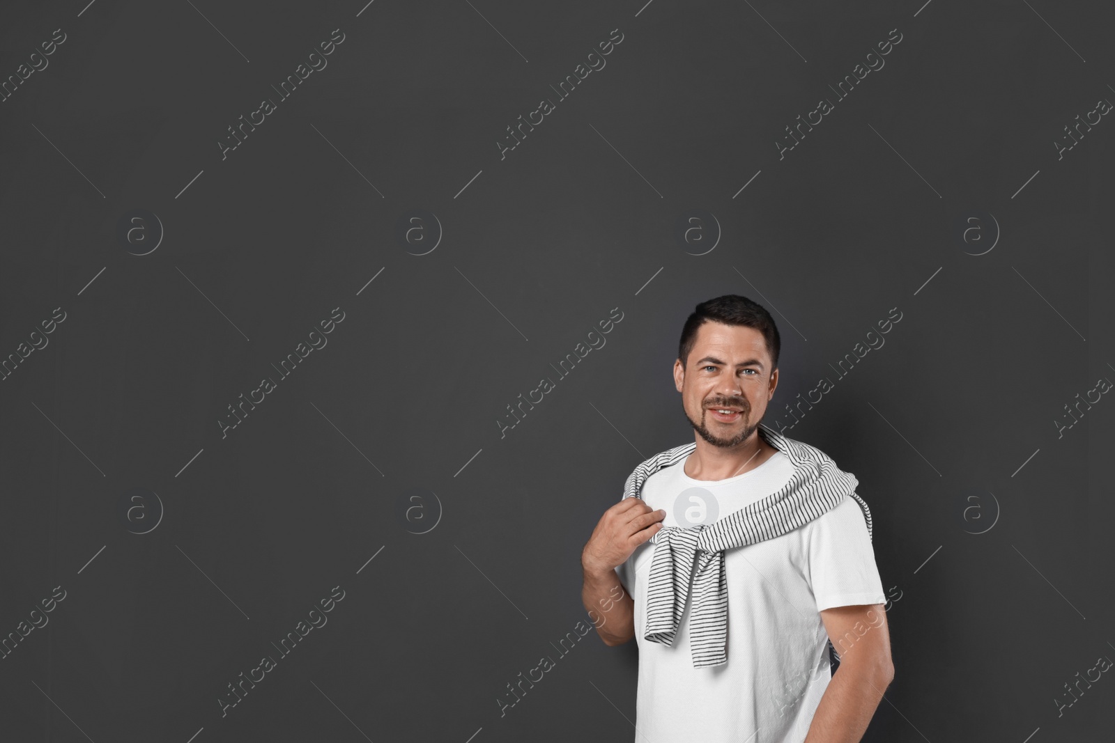 Photo of Portrait of handsome man on dark background. Space for text