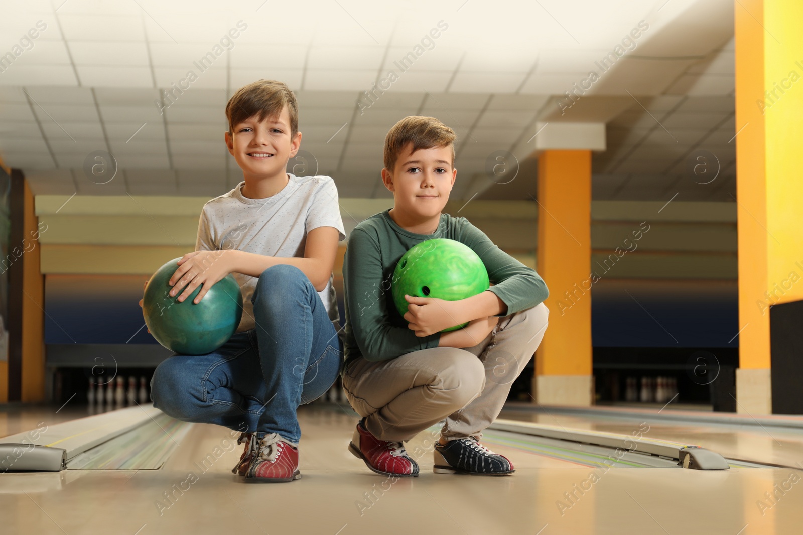 Photo of Happy boys with balls in bowling club