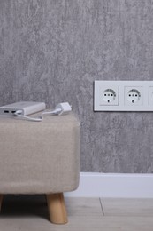 Electric power sockets on grey wall indoors