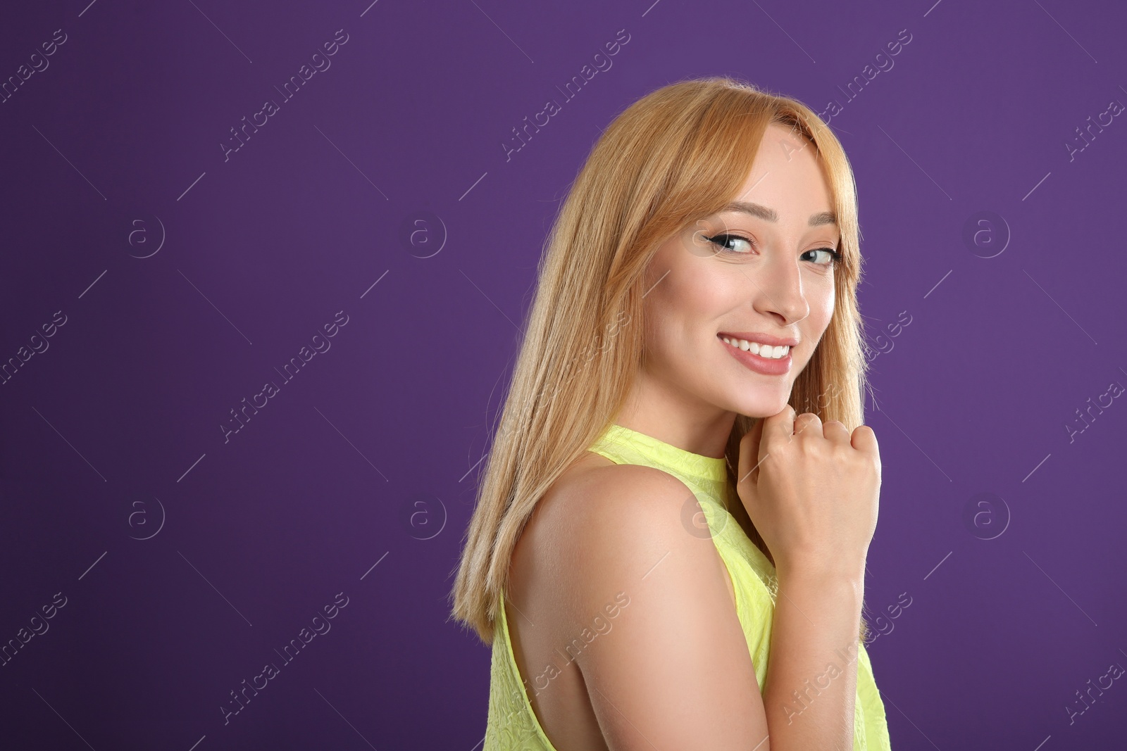 Photo of Beautiful young woman with blonde hair on purple background