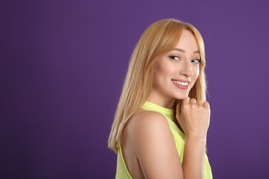 Photo of Beautiful young woman with blonde hair on purple background