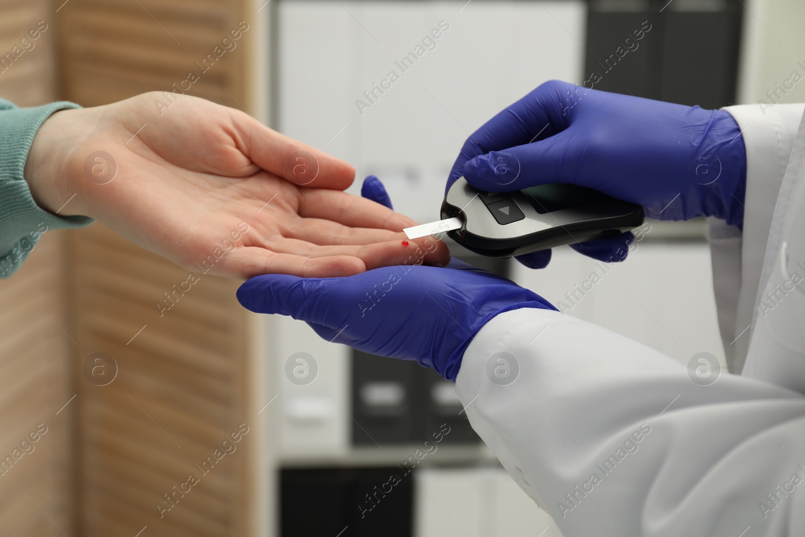 Photo of Diabetes. Doctor checking patient's blood sugar level with glucometer in clinic, closeup