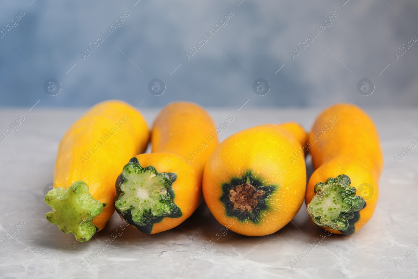 Photo of Fresh ripe yellow zucchini on grey table, closeup