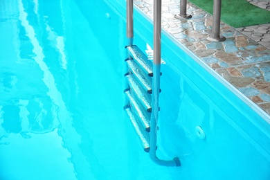 Modern swimming pool with stairs at resort