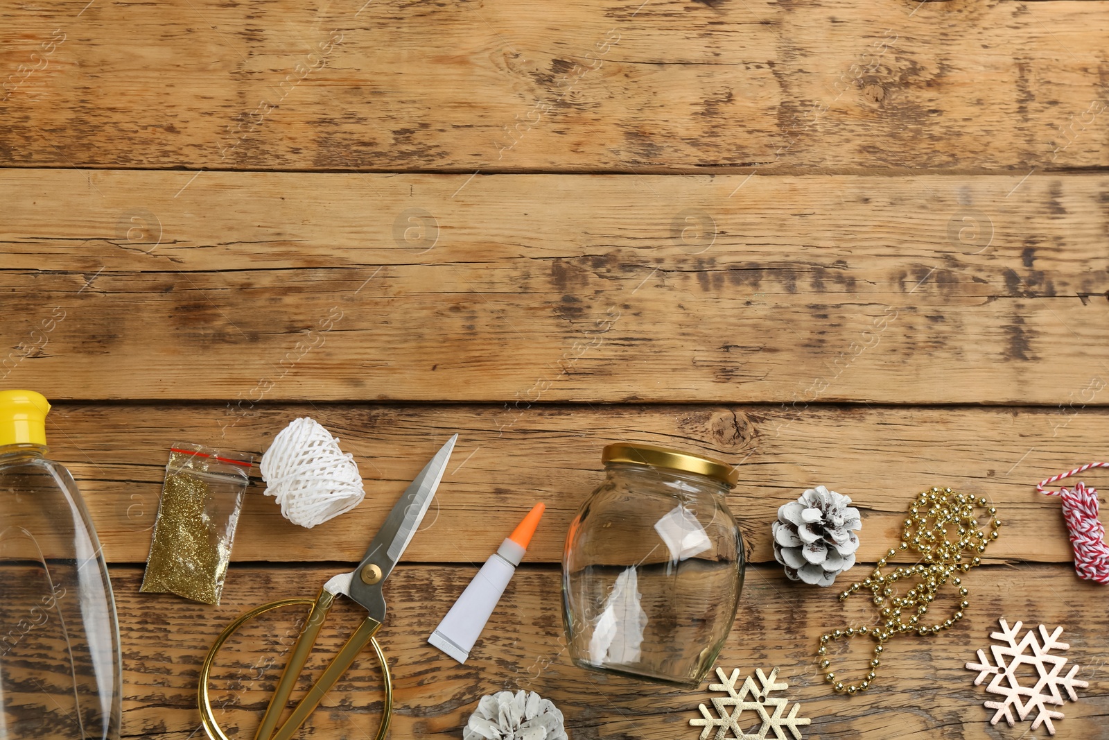 Photo of Instruments and materials for snow globe on wooden table, flat lay. Space for text