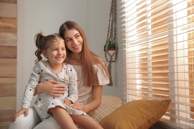 Photo of Happy mother with little daughter near window at home