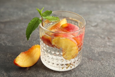 Photo of Tasty peach cocktail on table. Refreshing drink