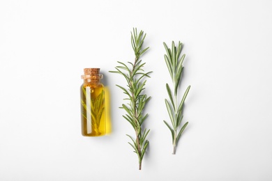 Composition with bottle of rosemary oil on white background, top view