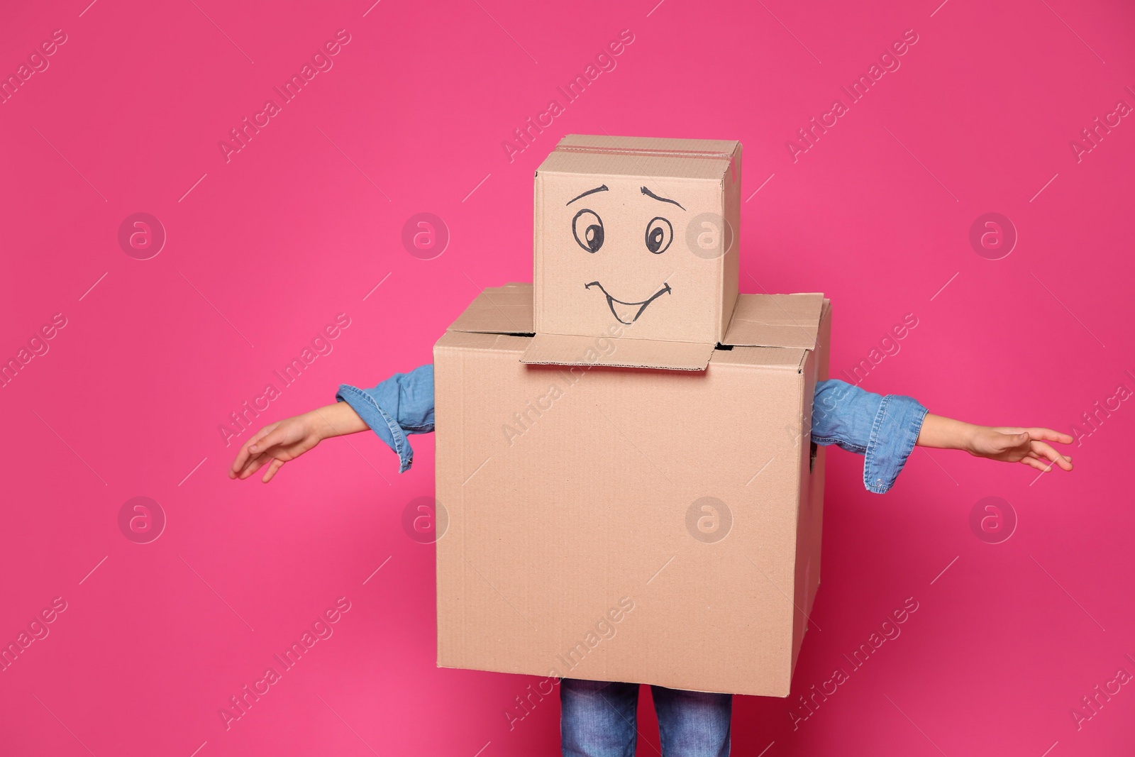 Photo of Cute little child in cardboard costume on color background