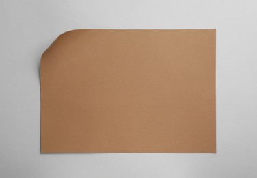 Sheet of brown paper on white background, top view