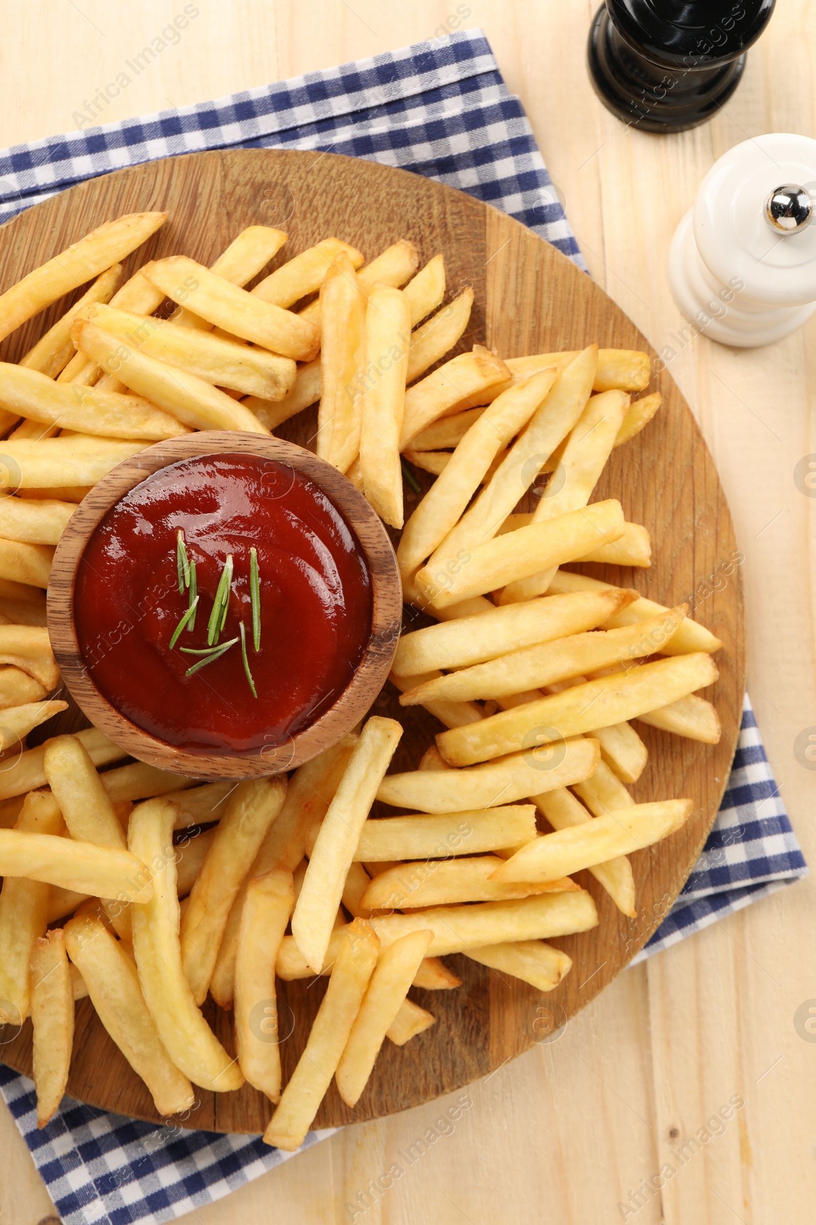 Photo of Delicious french fries served with ketchup on wooden table, flat lay