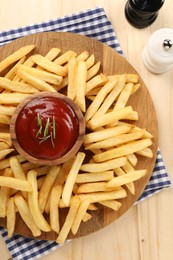 Delicious french fries served with ketchup on wooden table, flat lay