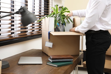 Photo of Businessman with moving box in office, closeup. Work promotion concept